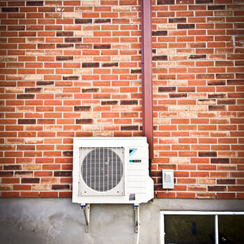 Outdoor wall-mounted unit installed on a brick wall